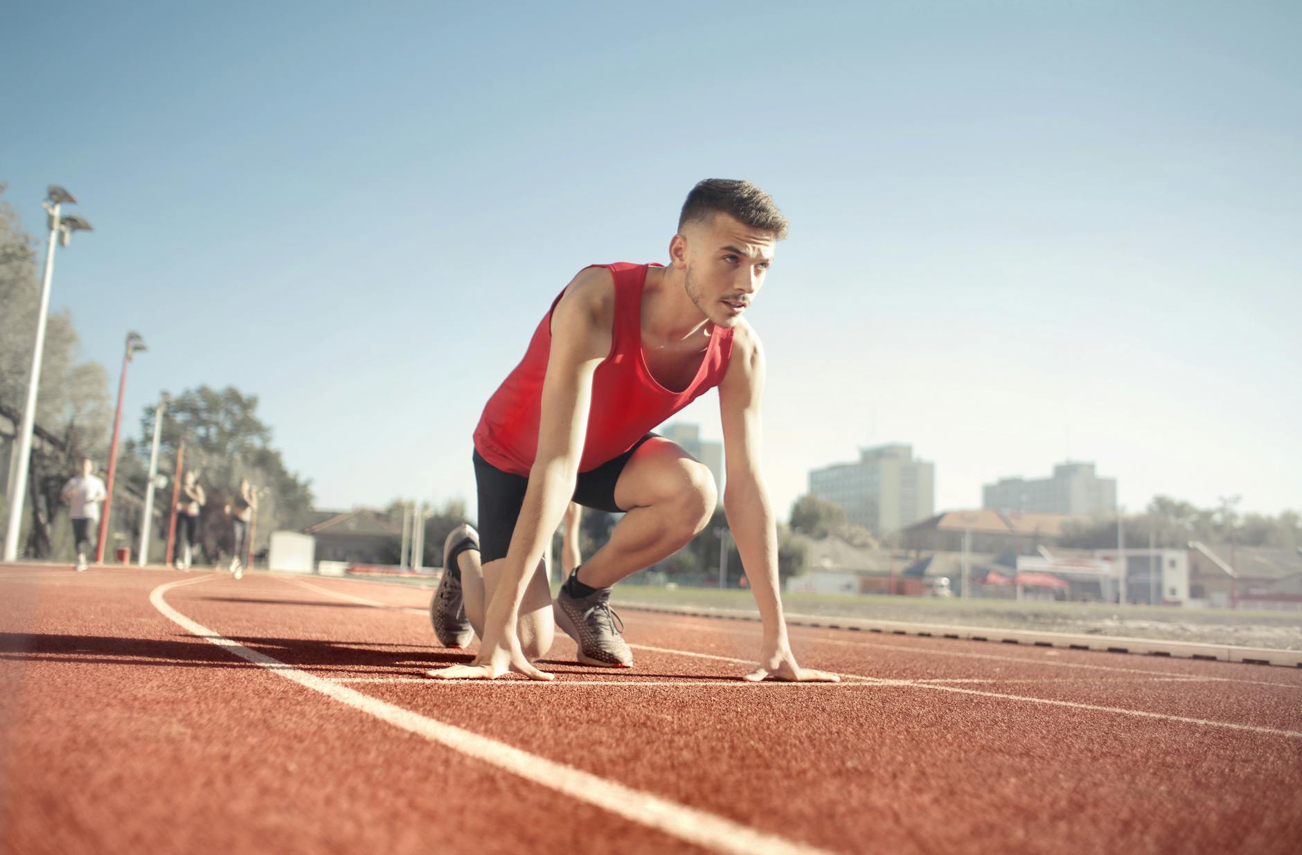 image of a man in starting pose to run on a track